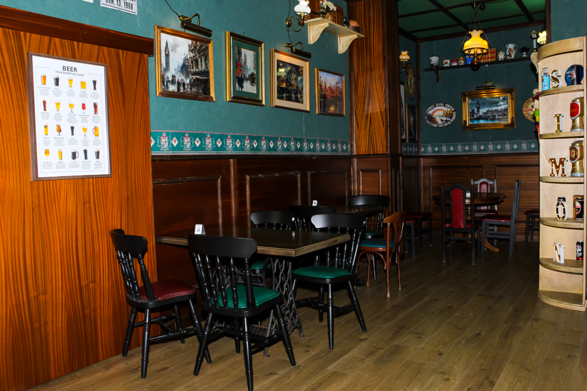 Sala interna con guida alle birre, quadri di Londra e arredi in legno